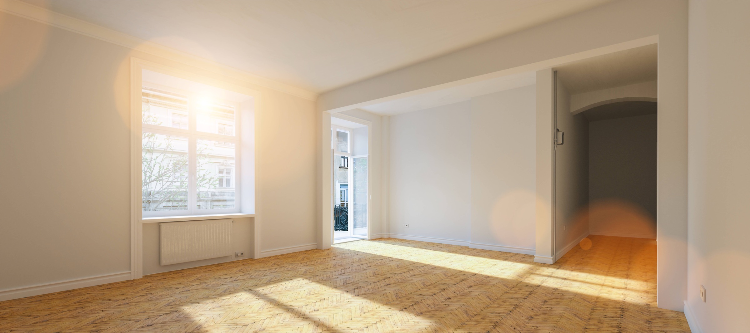 Pièce vide et lumineuse d’un appartement ancien, parquet et fenêtre